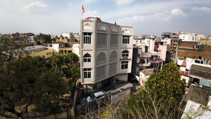 Un hôtel à plusieurs étages, doté de balcons, surmonté d’un drapeau et offrant une vue sur le quartier environnant.