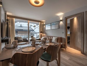 Zona pranzo moderna con tavolo grande, sedie e divano.