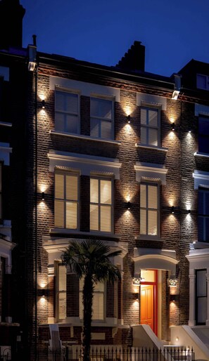 A two-story building with a brick facade, multiple windows, and exterior lighting. - Premium Studio 5 at The Orange Door Little Venice (Greater London)