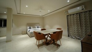 Ein Schlafzimmer mit Bett, Esstisch mit Stühlen, Deckenventilator und Klimaanlage.