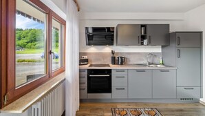 Uma cozinha moderna com forno embutido, micro-ondas e armários cinzentos.