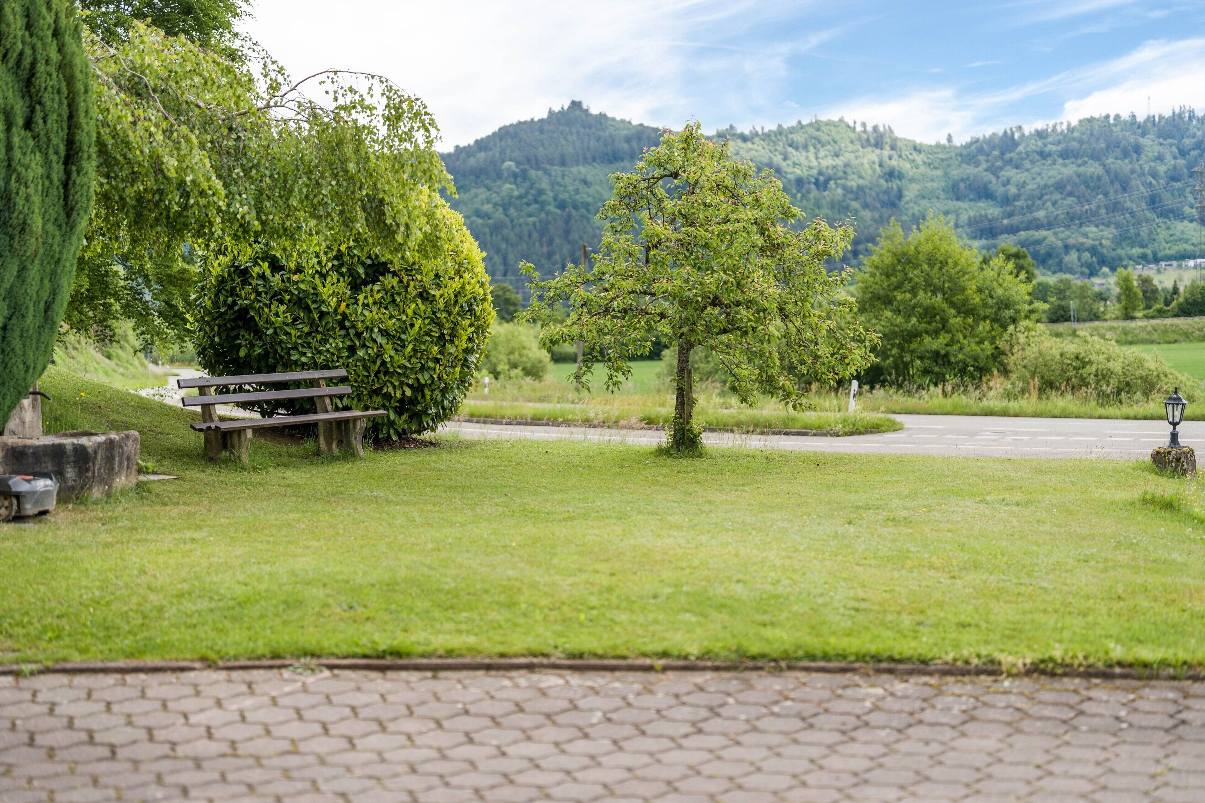 Ein Park mit Picknicktisch, Bänken und einem gepflasterten Weg.
