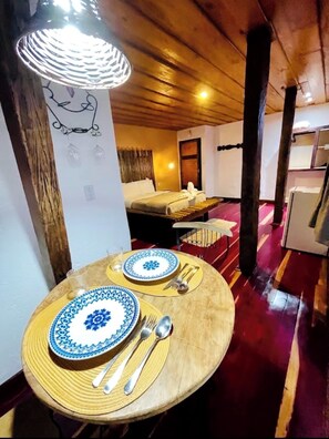 A dining table set with plates, cutlery, and a candle holder.