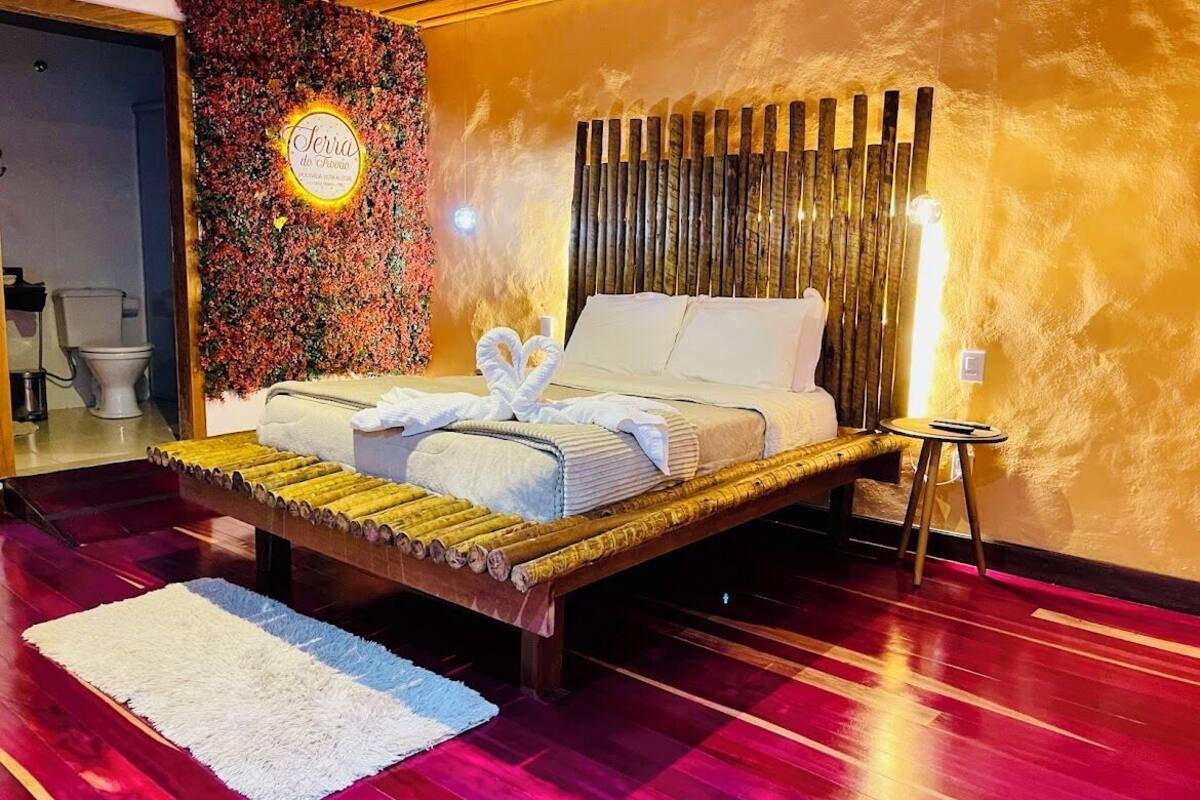 Una cama de diseño singular, una pared con estampado floral y una mesita de noche pequeña.