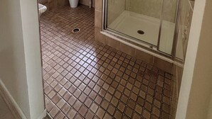 Un baño con ducha, lavamanos e inodoro.