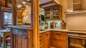 A kitchen with wooden cabinets, a Siemens oven, and a hanging light fixture. - Cozy 2BR Apartment in Courchevel 1850 – Center, Close to Slopes, WiFi, Hammam, Ski Locker (Courchevel)