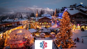 A snow-covered village with a prominent dome structure, a large illuminated Christmas tree, and a mountain backdrop. - Cozy 2BR Apartment in Courchevel 1850 – Center, Close to Slopes, WiFi, Hammam, Ski Locker (Courchevel)