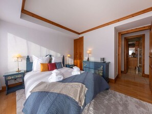 A bedroom with a bed, bedside tables, a dresser, a mirror, and a door leading to a bathroom. - Courchevel 1850 - Apartment 4 pers, ski-in/ski-out, wifi, parking (Courchevel)