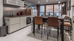 Una cocina moderna con comedor, vistas a la ciudad y un balcón.