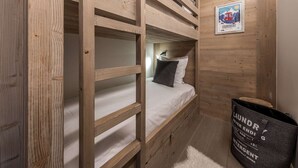 A bunk bed room with a poster on the wall and a laundry bag on the floor. - Modern apartment Courchevel 1550, 4 people, parking, wifi (Courchevel)