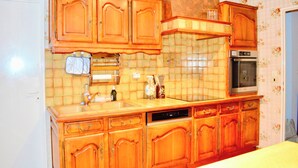 A kitchen with wooden cabinets, a dishwasher, and a built-in oven. - Garden House 3bedrooms, parkingFREE, wifi, 15minLR (Nieul-sur-Mer)
