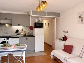 Eine kompakte Küche mit Essbereich, einer Mikrowelle und einem Kühlschrank.