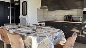Ett modernt kök med mörka skåp, en mikrovågsugn och en kaffebryggare.