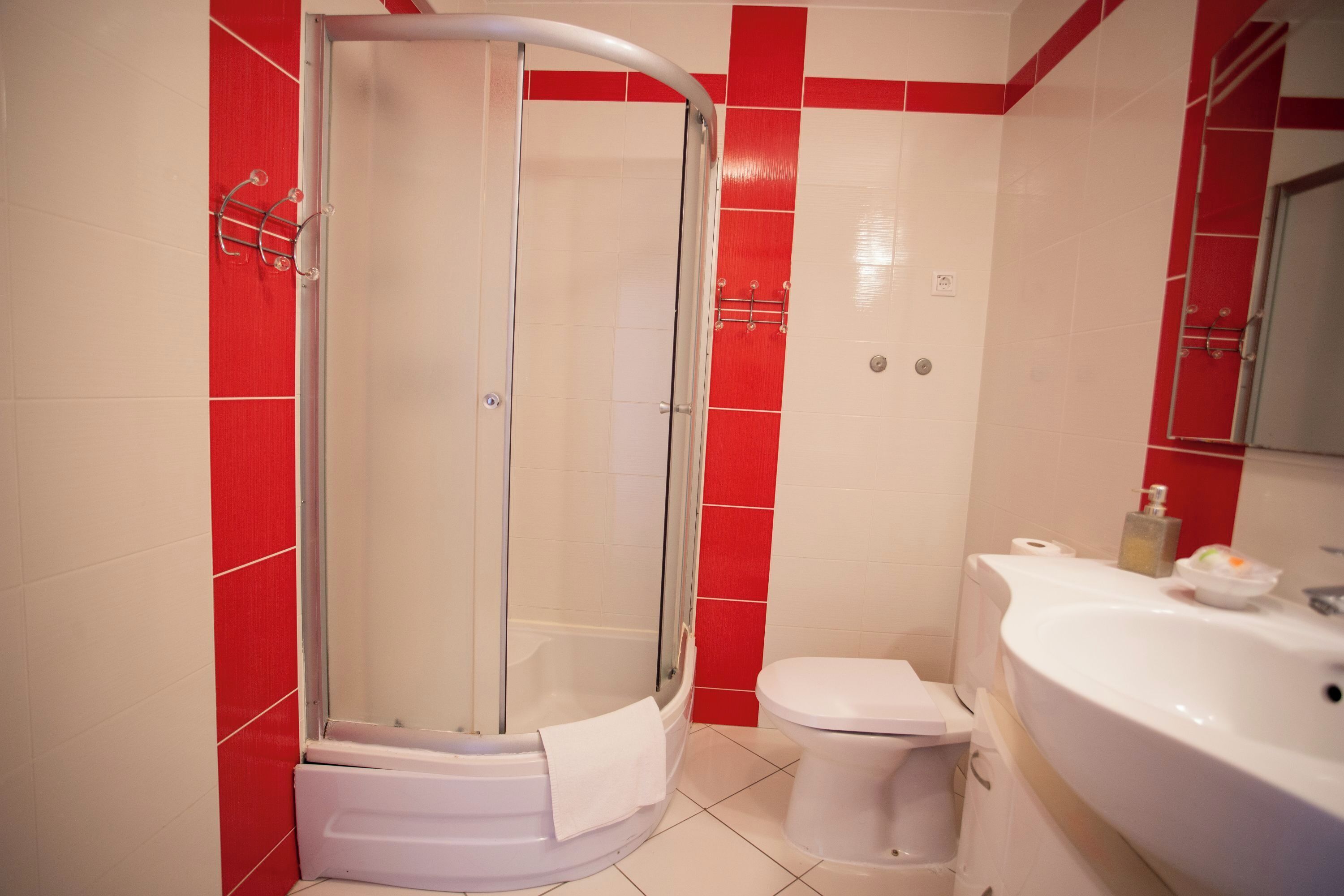 A bathroom with a shower, toilet, and sink.