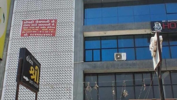 A building with a sign reading 'Shiv Business' and 'The Cactus Company' on the ground floor. - HOTEL KRISHNA INN (Ahmedabad)