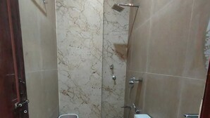 A bathroom with a toilet, bidet, and shower. -  Shri Khatu Shyam Residency (Varanasi)