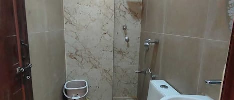 A bathroom with a toilet, bidet, and shower.