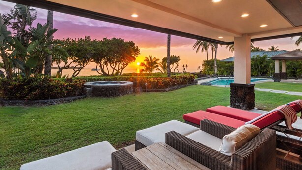 A covered outdoor area with a pool, lounge chairs, and a sunset view. - 4 BR Oceanfront Home with theater - Hilton Waikoloa Access Included (Waikoloa)