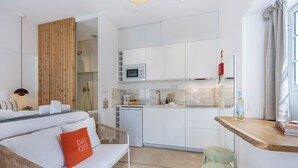 Una cocina moderna con gabinetes blancos, microondas y cafetera.