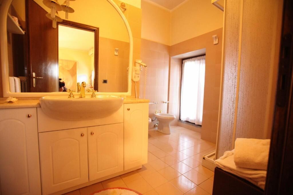 Une salle de bain avec un lavabo, un miroir et des toilettes.