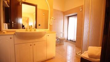 Une salle de bain avec un lavabo, un miroir et des toilettes.