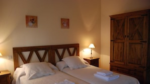 A double bed with white bedding, two bedside tables with lamps, wooden headboard, and a wardrobe. - Casa Rural Las Navillas: vistas a la montaña, Wi-Fi y aire acondicionado (Las Navillas)