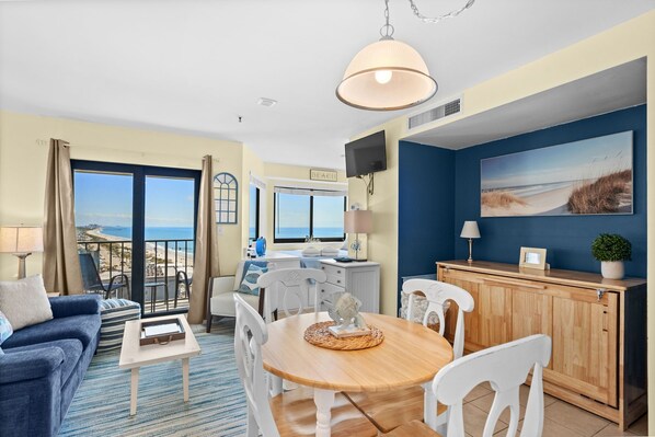 A room with a balcony, a dining area, a TV, and a painting. - T1107 at the Myrtle Beach Resort (Myrtle Beach)