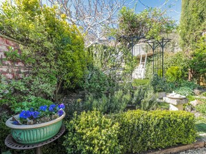 A garden with a variety of plants and a stone bench. - 7 The Cedars (Wotton-under-Edge)