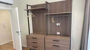 Une pièce comprenant une armoire dotée de nombreux tiroirs et d’étagères, d’une tringle pour suspendre les vêtements et d’une porte avec une poignée.