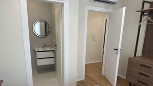Une chambre à coucher comprenant un lit, une commode, un miroir et une salle de bain avec un lavabo et des toilettes.