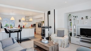 Una sala moderna con sofá, mesa de centro y mueble para televisión.