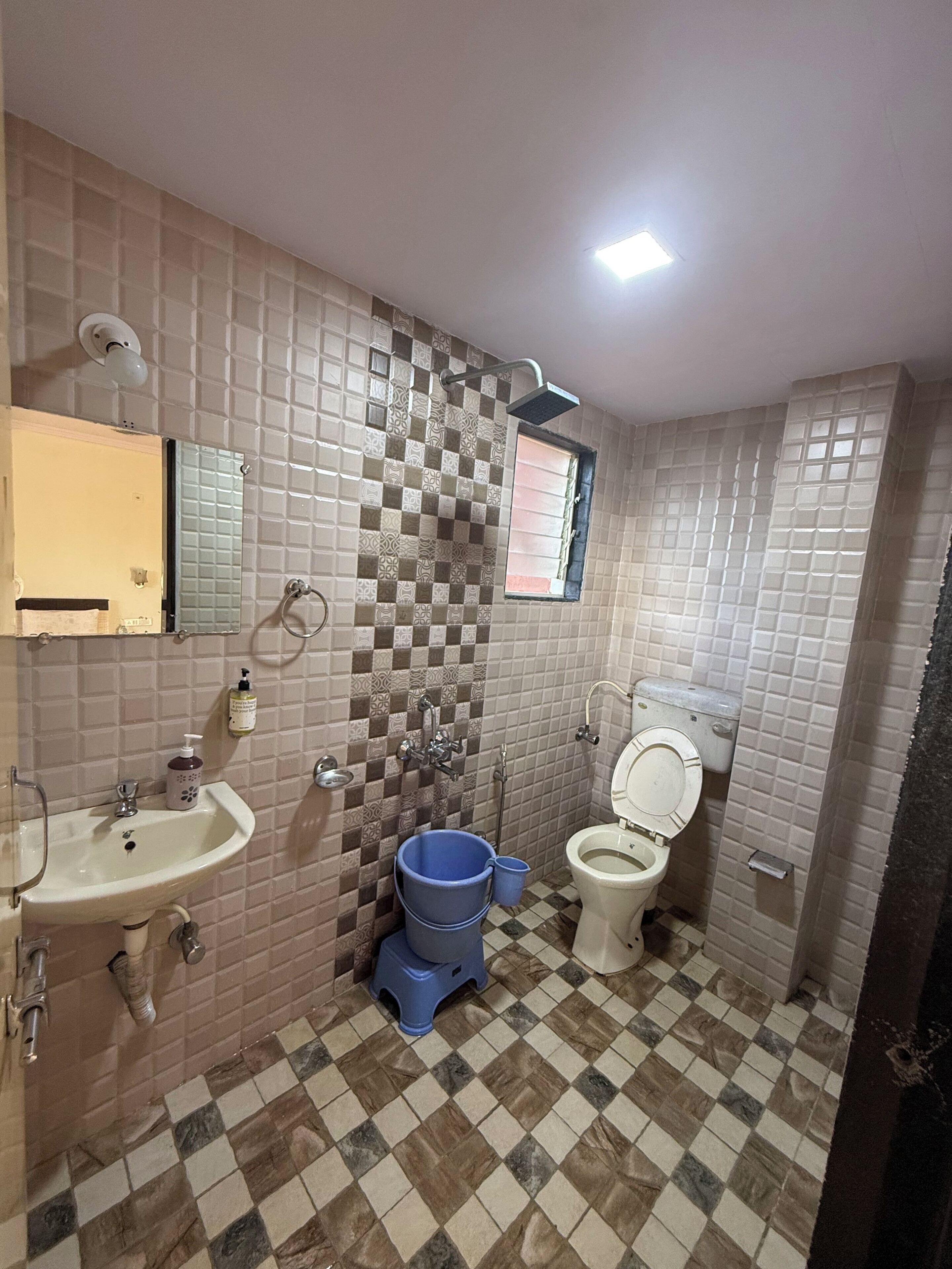 Un baño con lavamanos, inodoro y ducha.