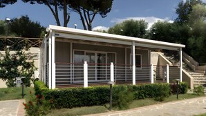 A building with a covered porch, a staircase, and a stone pathway. - Sea View - 40 Parallelo Mobile Home (Camerota)