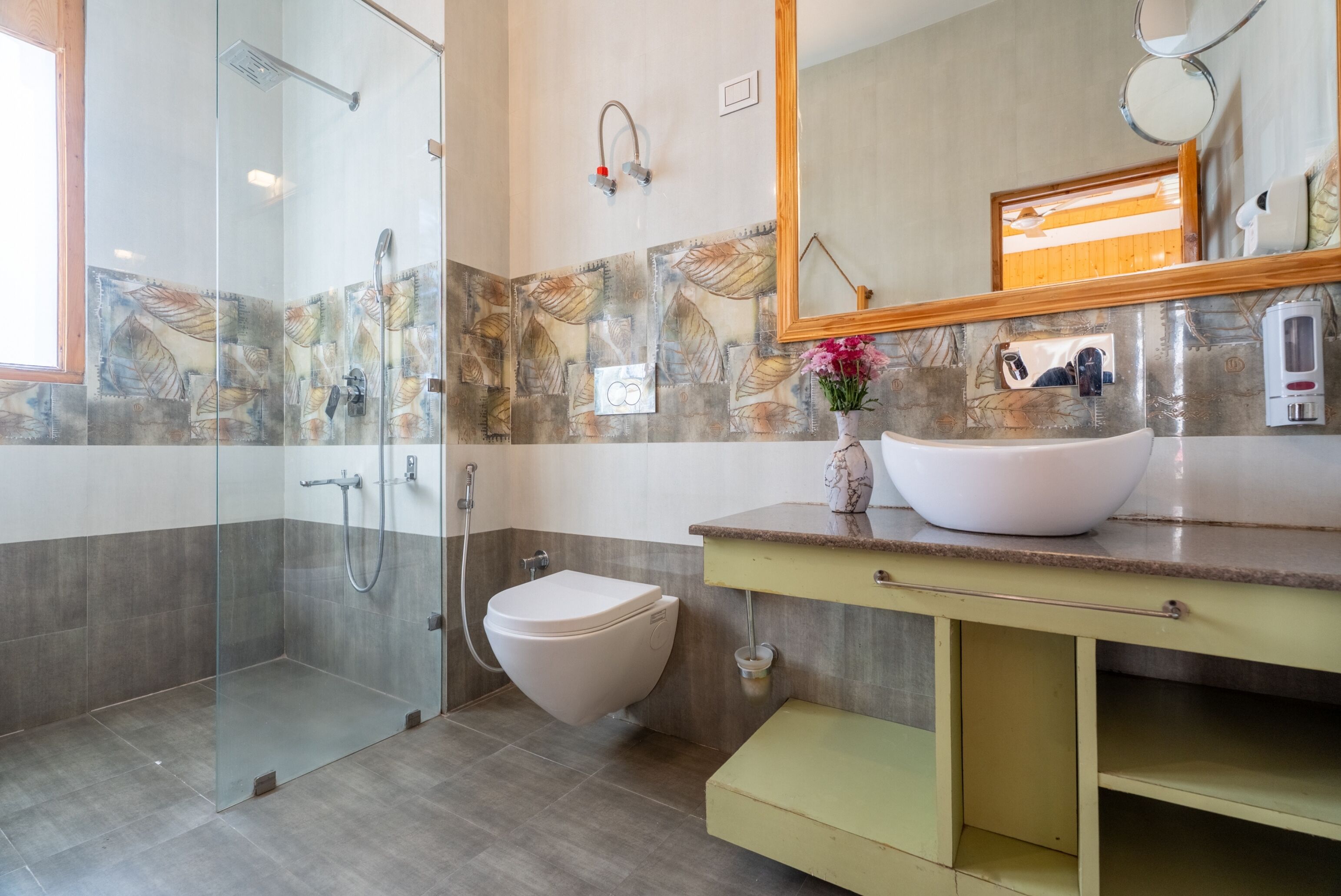 A modern bathroom with a glass shower enclosure, a toilet, a sink with a marble basin, and a mirror above the sink.
