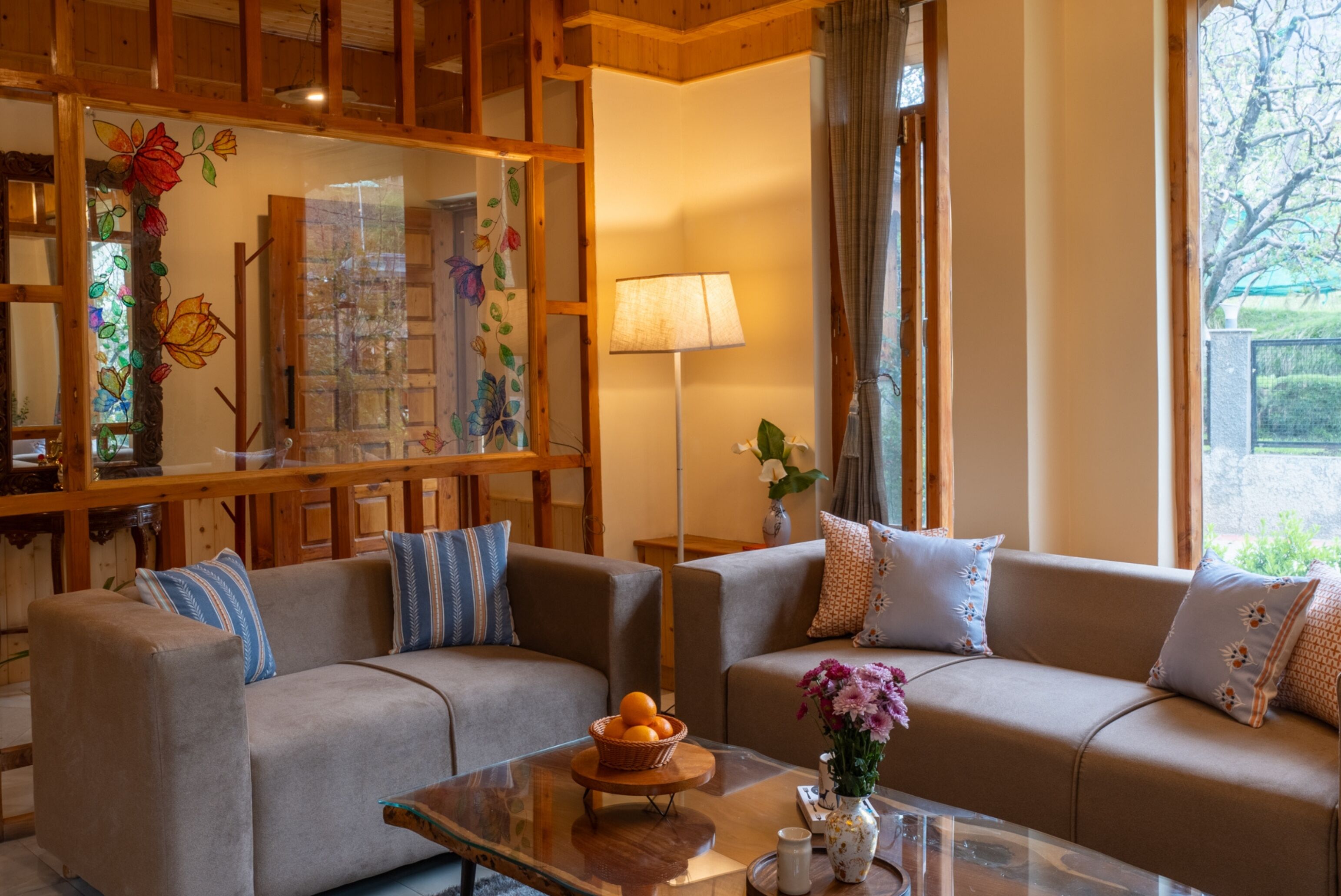 A cozy living room with two sofas, a coffee table with fruit, and a decorative vase.