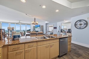 A spacious kitchen with a large island, built-in appliances, and a view to the outside. - Caribe Resort 911D by Liquid Life (Orange Beach)