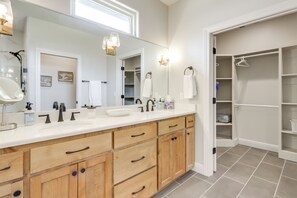 A bathroom with a large mirror, two sinks, wooden cabinets, and a walk-in closet. - Steps From the Water! Grand Lake Getaway w/ Patio (Afton)