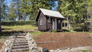 A rustic cabin with a metal roof, wooden steps, and a small porch. - Peaceful Farm Stay Near Spokane: Inland Hideaway! (Chattaroy)