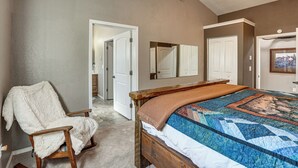 A bedroom with a wooden bed, a chair, a ceiling fan, and a door leading to another room. - Peaceful Farm Stay Near Spokane: Inland Hideaway! (Chattaroy)