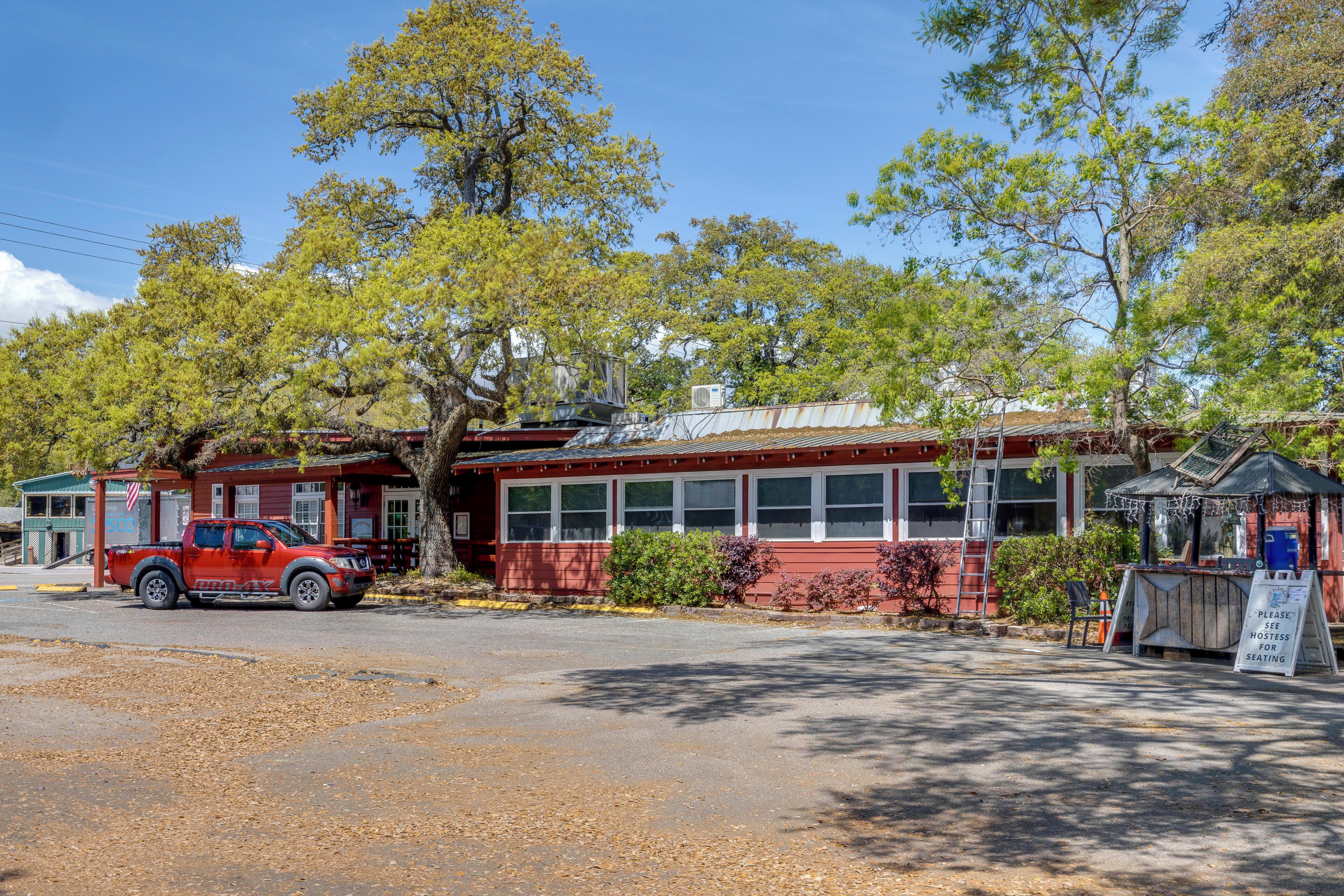 Un bâtiment rouge avec une grande fenêtre, un camion garé devant et une enseigne.
