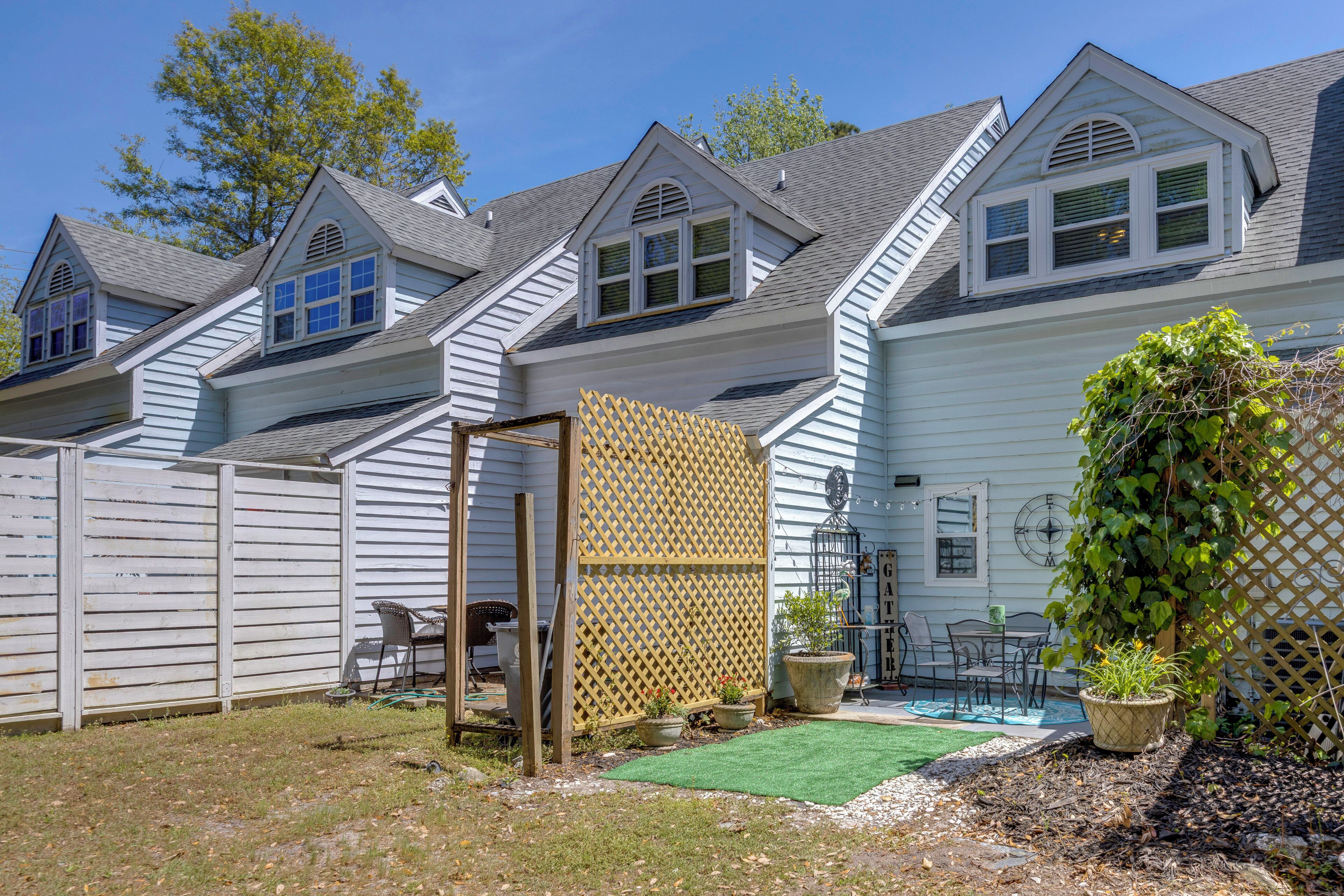 A residential property with a fenced backyard, a small patio area, and a visible garage door.