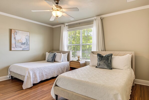A bedroom with two beds, a ceiling fan, a window with curtains, and a painting on the wall. - 3 Mi to Fsu! Townhome w/ Pool Access (Tallahassee)