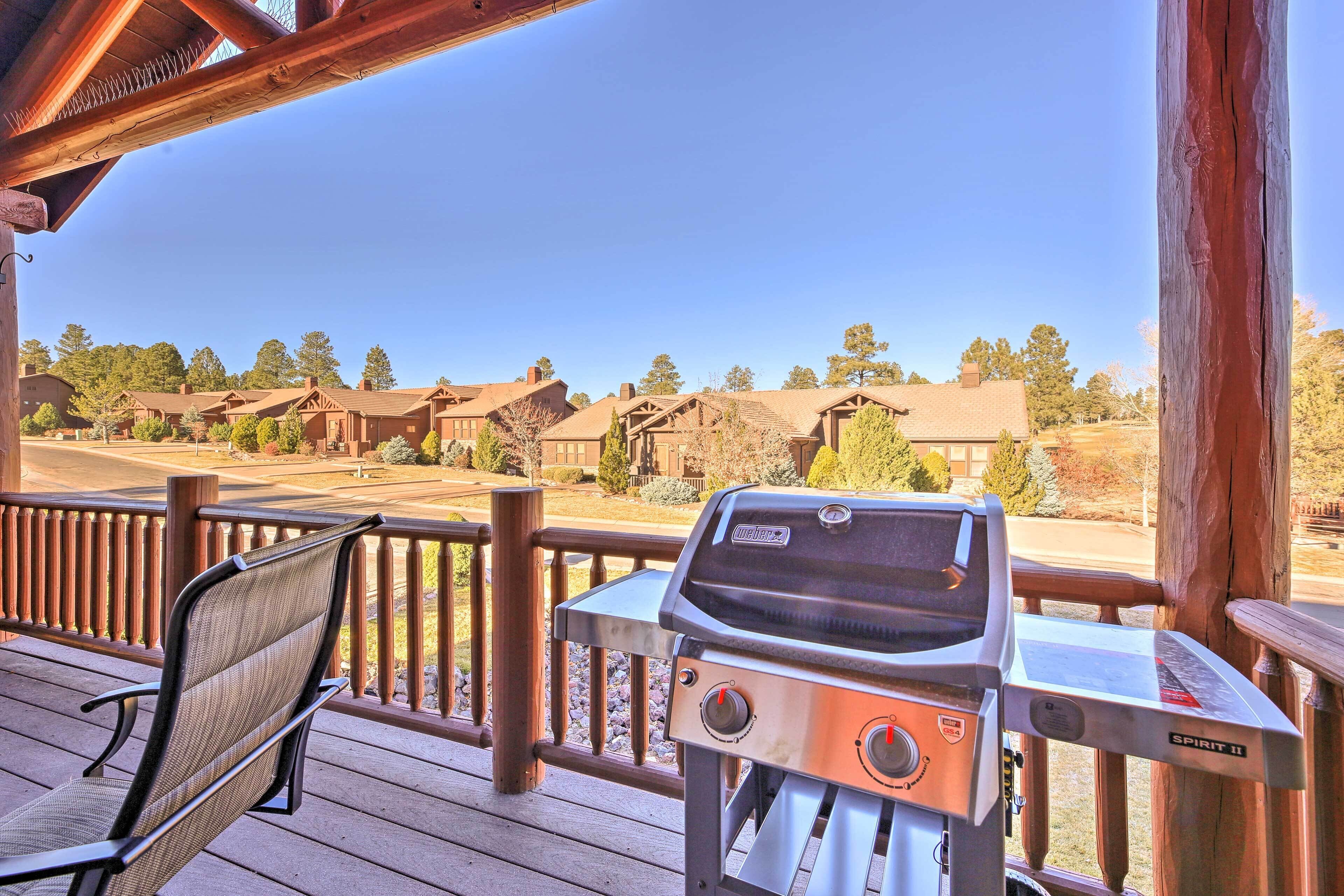 Una terraza de madera con una parrilla y una silla, con vistas a una hilera de casas.