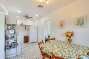 A compact kitchen with a ceiling fan, a refrigerator, and a dining area with a table and chairs. - Route 66 Roadtripper Retreat w/ Private Backyard (Kingman)