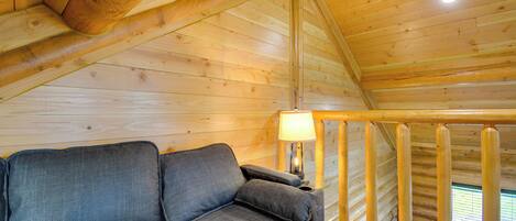 Ambiente in legno con un divano, una lampada e una finestra.
