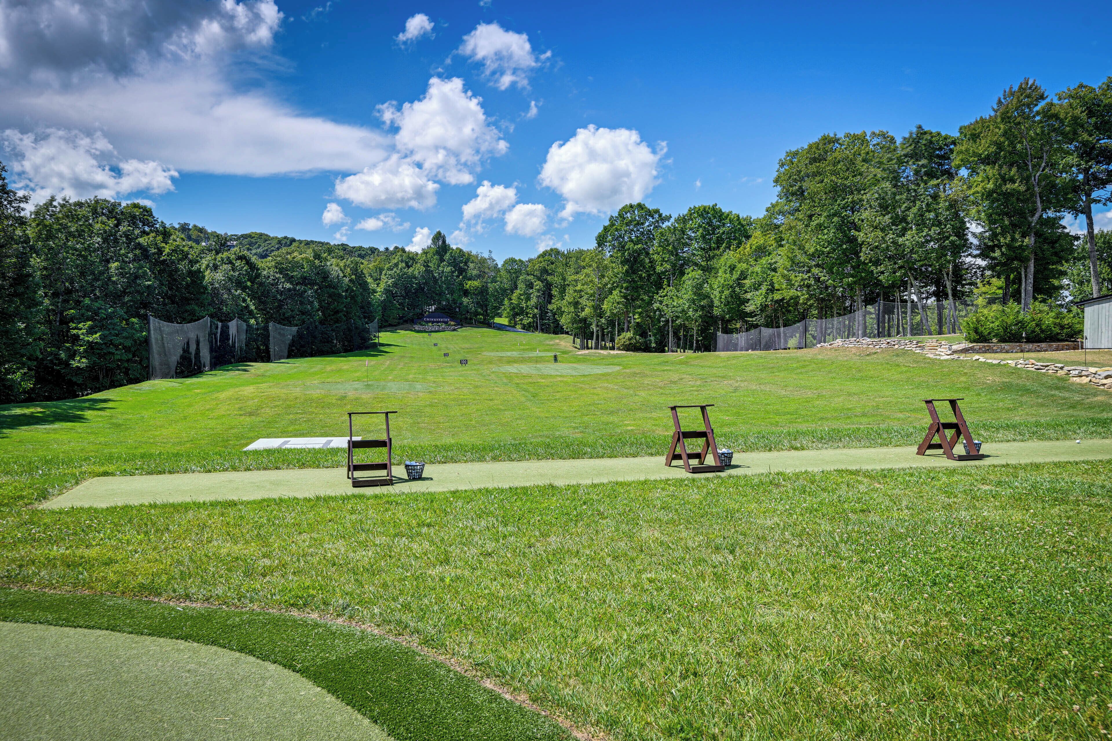 Un campo de golf con tres zonas de salida de madera y un putting green.