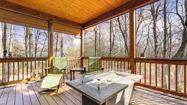 A wooden deck with a glass-top hot tub, wooden chairs, and a view of a forest. - Mountain Retreat w/ Community Perks in Glenville! (Glenville)