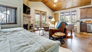 A spacious living area with a fireplace, a sofa, a chair, and a dining table. - Mountain Retreat w/ Community Perks in Glenville! (Glenville)