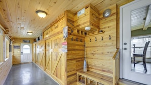 Un intérieur en bois avec un banc, une porte et une pagaie fixée au mur.
