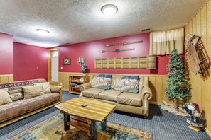 A living room with a sofa, a coffee table, a small Christmas tree, and a ladder against the wall. - Family Escape in Crystal Mtn Resort! 13 Mi to Lake (Thompsonville)